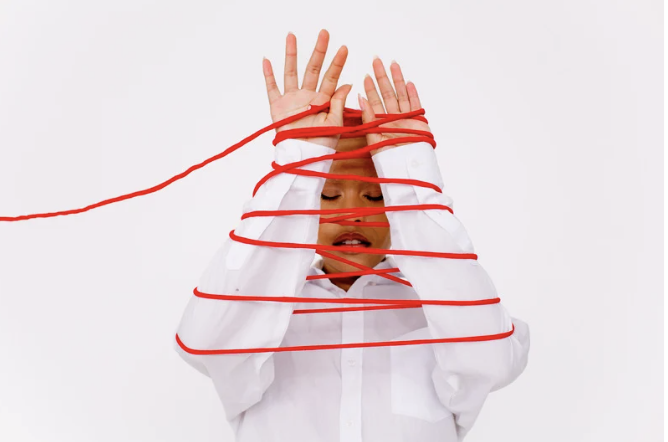 Woman wrapped up in red thread