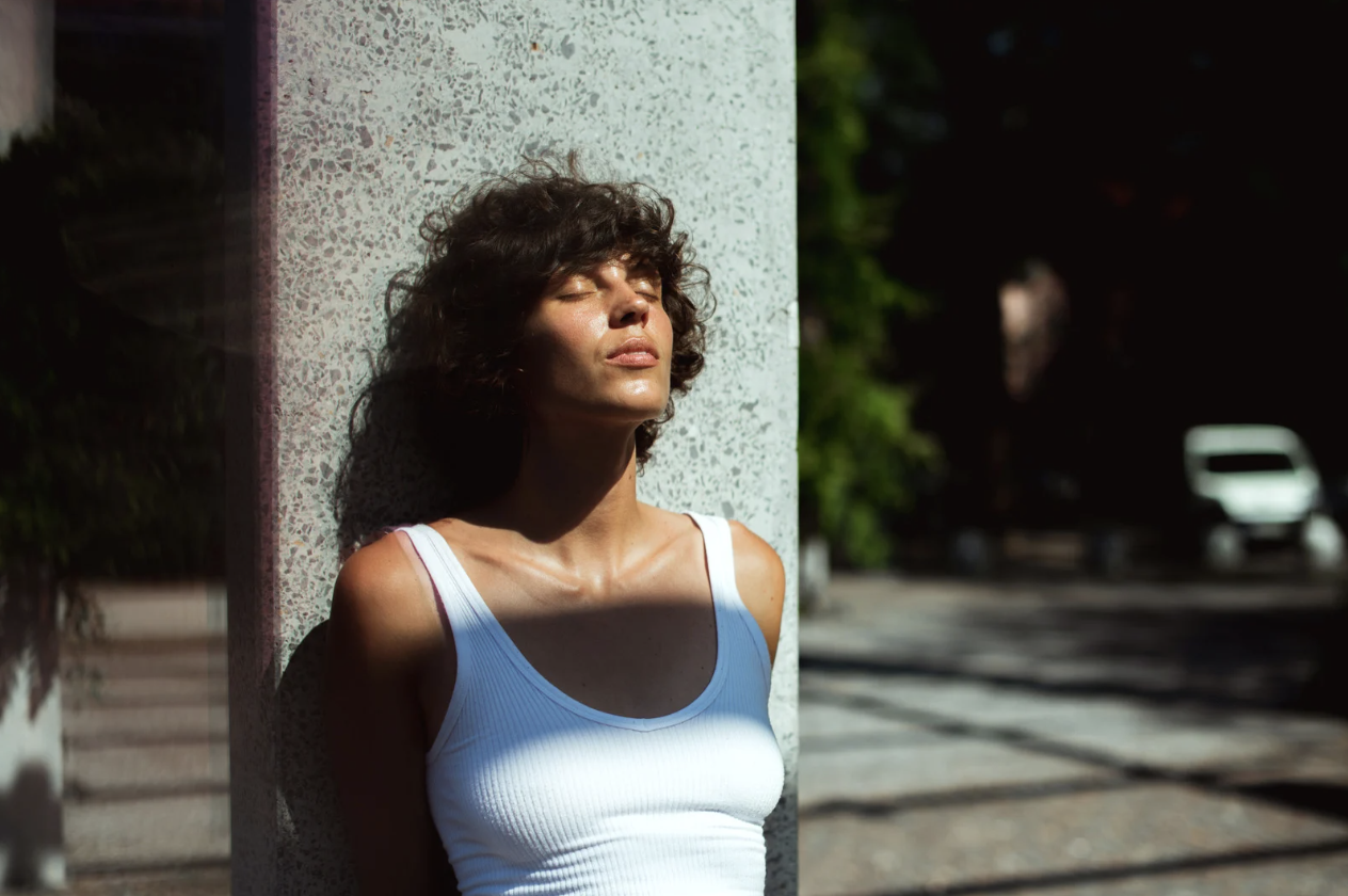 Person standing with their face to the sun and their eyes closed.