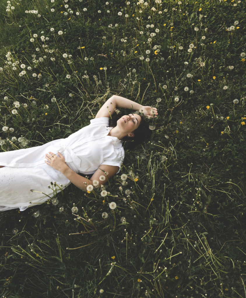 Woman laying in a dandelion field
