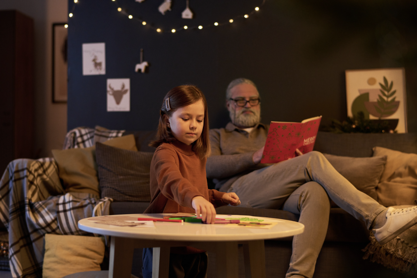 Father reading while child plays