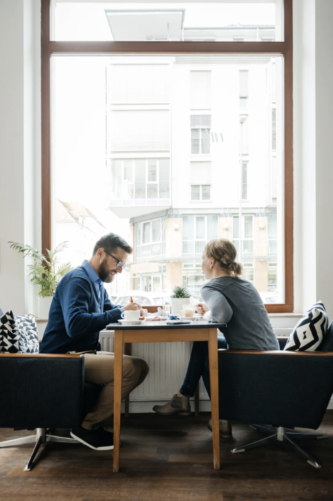 man and woman having coffee together in a bright room