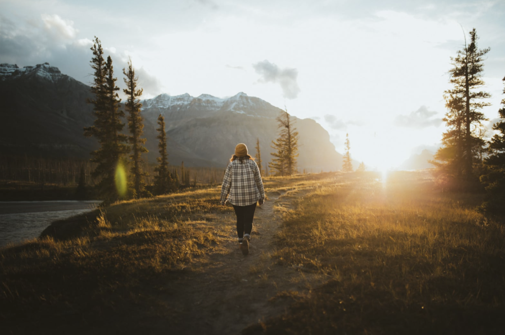 A person walking in nature at sunset.