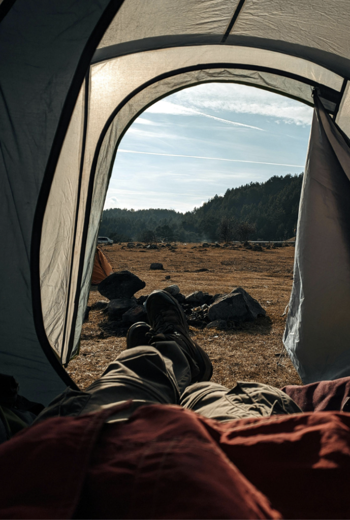 POV laying in a tent looking out the door at nature